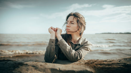 Portrait of young woman sitting at beach