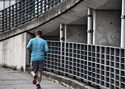 Rear view of man jogging in city
