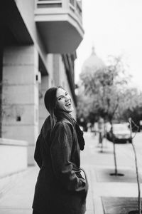 Portrait of smiling woman standing in city