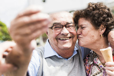 Portrait of smiling senior man taking selfie with his wife