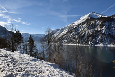 Scenic view of frozen lake by mountain against sky