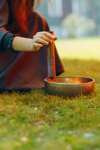 Midsection of woman sitting on grass