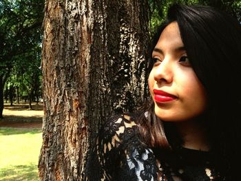 Close-up portrait of woman with tree trunk