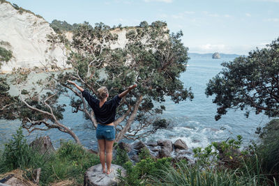 Full length of woman standing on mountain against sky