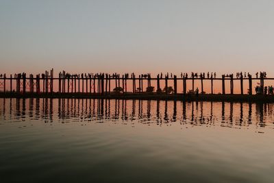 Pier on lake against clear sky during sunset