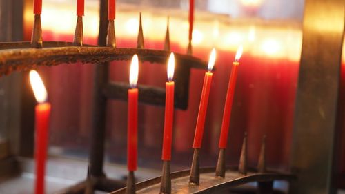 Close-up of lit candles in temple