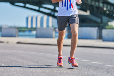 Running man. athletic man jogging in sportswear on city road. healthy lifestyle, fitness sport hobby