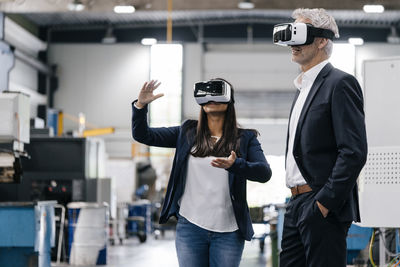 Businessman an woman in high tech enterprise, using vr glasses