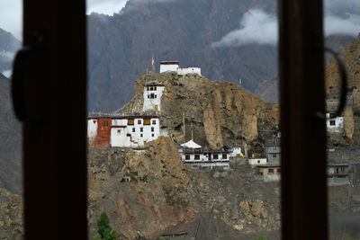 Built structure by mountains against sky