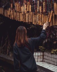 Rear view of woman touching religious decoration