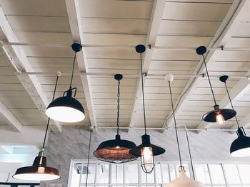 Low angle view of illuminated light bulbs hanging from ceiling