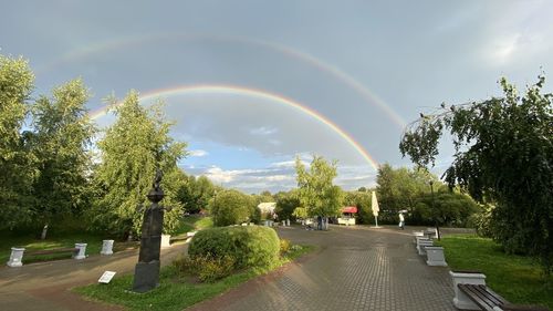 Rainbow over road in city against sky