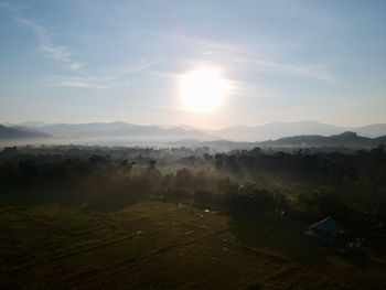 Scenic view of field against bright sun