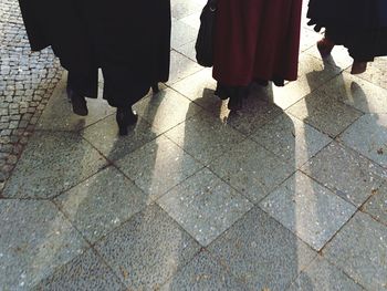 Low section of people standing on tiled floor