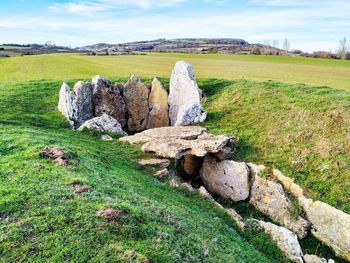 View of rocks on field against sky