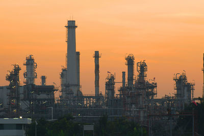 View of factory against orange sky