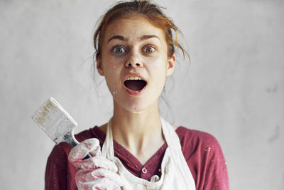 Close-up portrait of young woman using mobile phone