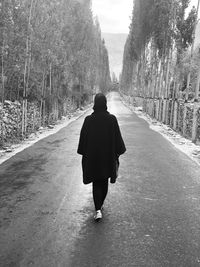 Rear view of woman walking on footpath