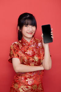 Portrait of woman holding red camera