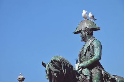 Low angle view of statue against clear blue sky