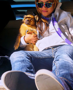 Young woman with dog sitting in sunglasses