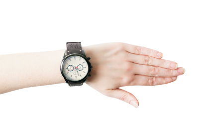 Close-up of hand with wristwatch against white background