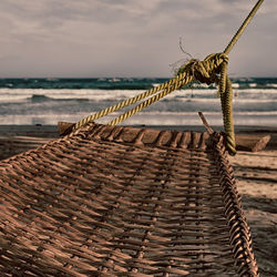 Close-up of rope at beach against sky