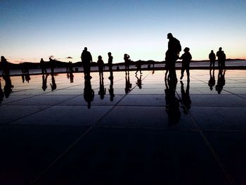 Silhouette people on footpath against sky during sunset - salutation to the sun in zadar croatia