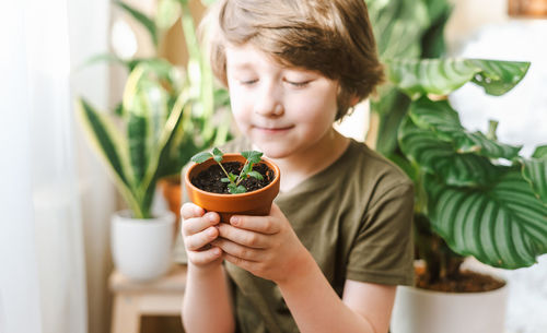 Midsection of boy holding plant