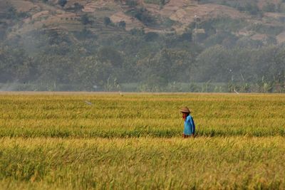 Side view of man standing on field