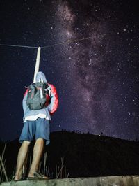 Full length of man standing against star field at night