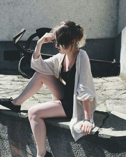 Woman sitting on retaining wall