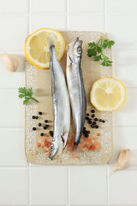 Fresh capelin fish or shisamo baby fish on white tile table background