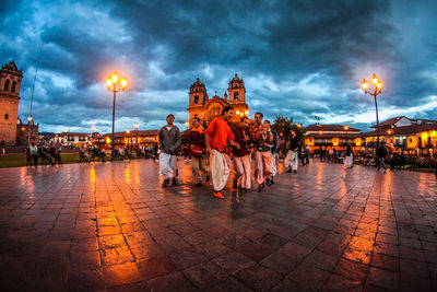 People sitting in town square at dusk