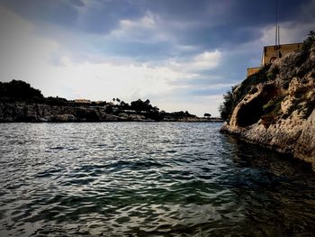 Scenic view of sea by buildings against sky