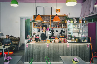 Portrait of confident female barista at cafe counter