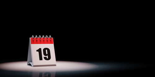 Information sign on table against black background