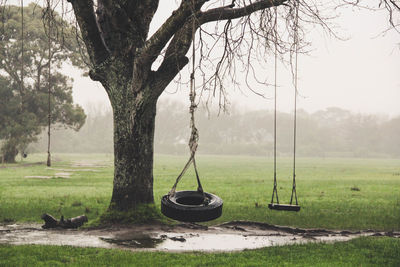 View of empty swing on field against sky