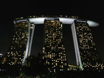 Low angle view of illuminated city against sky at night