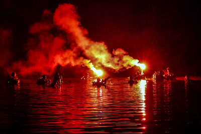 Panoramic view of people on fire at night