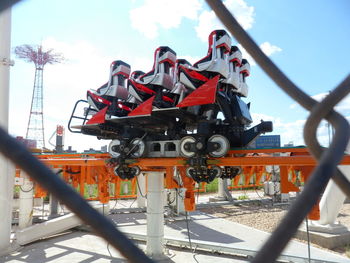 Rollercoaster seen through chainlink fence