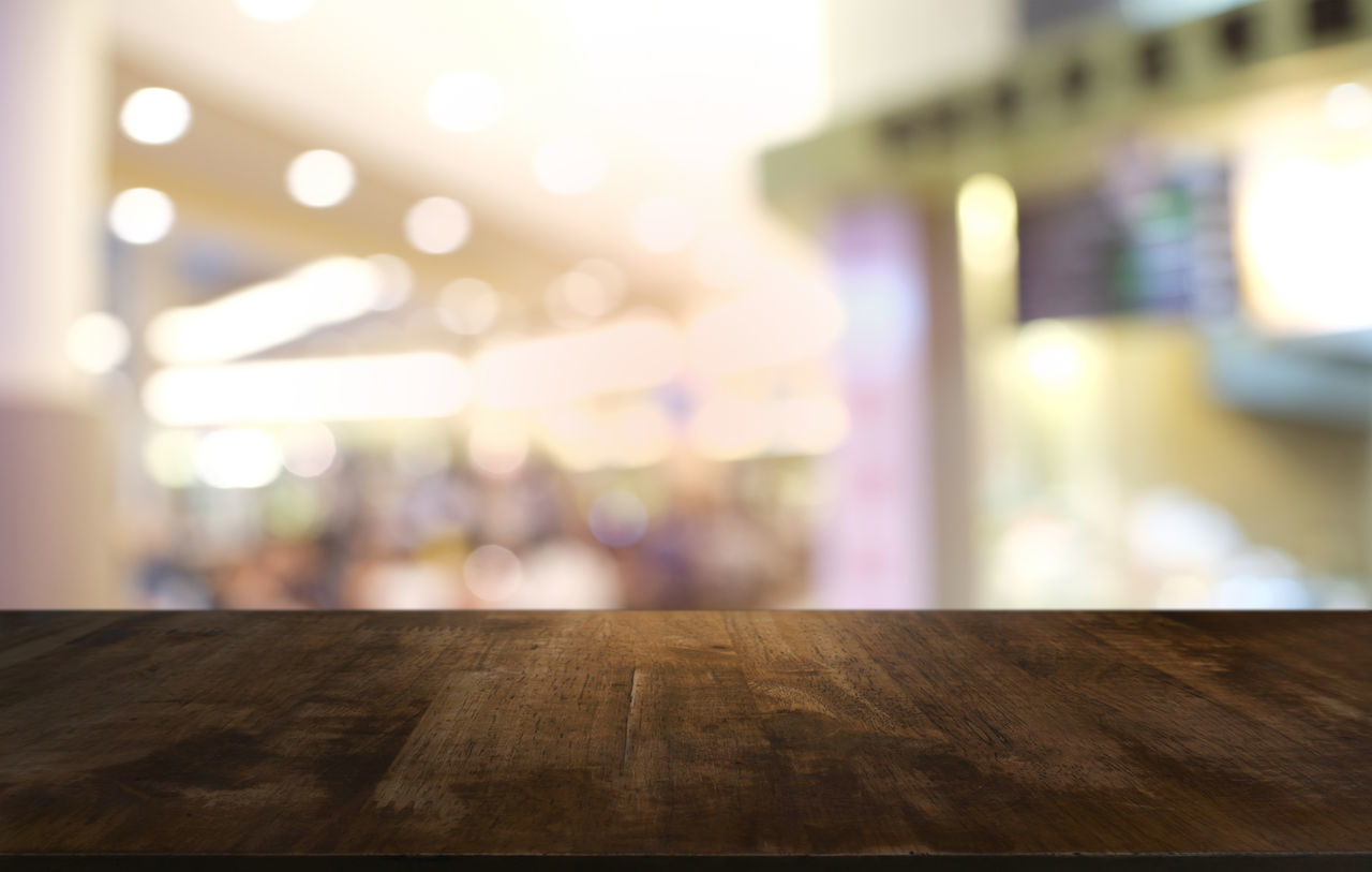 DEFOCUSED IMAGE OF ILLUMINATED LIGHT AT TABLE
