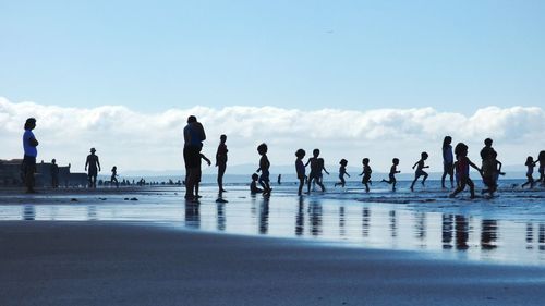 People on beach against sky