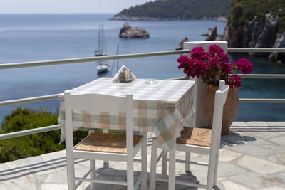 Restaurant tables by the sea outdoor terrace with a few yachts in the background in skopelos, greece