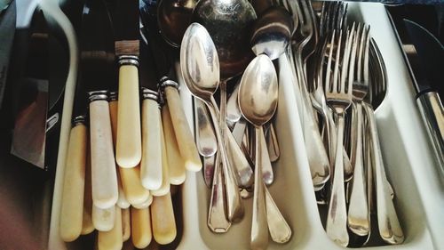 Close-up of eating utensils in container for sale at stall