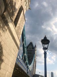 Low angle view of street light against cloudy sky