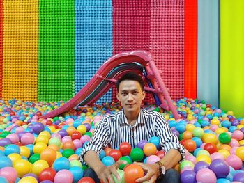 Portrait of a smiling young man holding multi colored umbrella