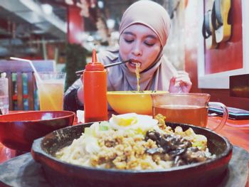 Close-up of woman eat noodle on table