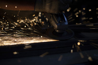 Sparks from grinding. metal work. steel profile cutting parts. lights in dark. 