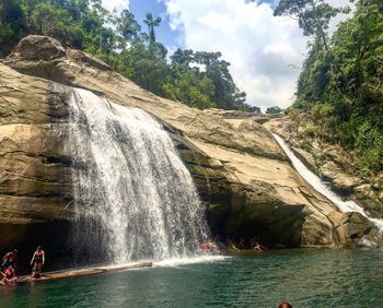 Scenic view of waterfall against sky